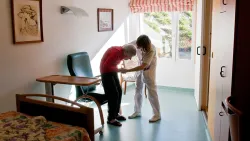 Nurse Woman Helping Senior With Walker